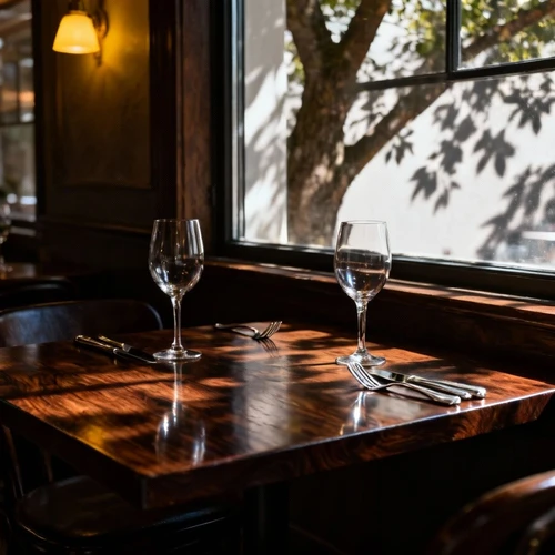 参考风格图：深色胡桃木餐桌，旁边放着银质刀叉和高脚杯，窗外透进斑驳的树影，复古且高级的西餐厅氛围